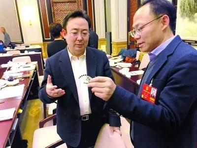 昨天,北京團(tuán)小組會休息的間隙,程京代表(右)向夏林茂代表介紹基因芯片。張宇攝